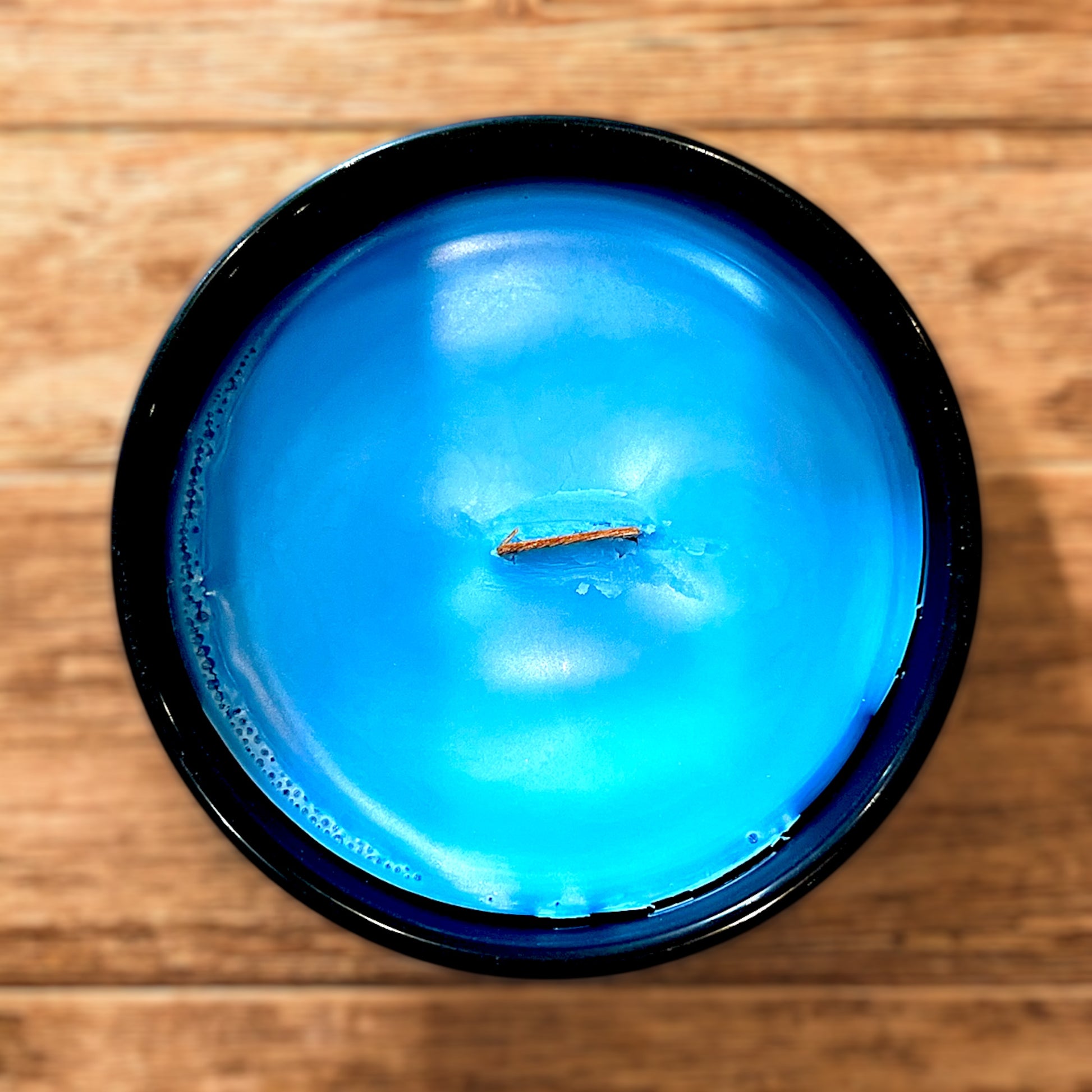 The stunning blue beach themed color depicting the wooden wick that helps release the aroma of this tropical candle