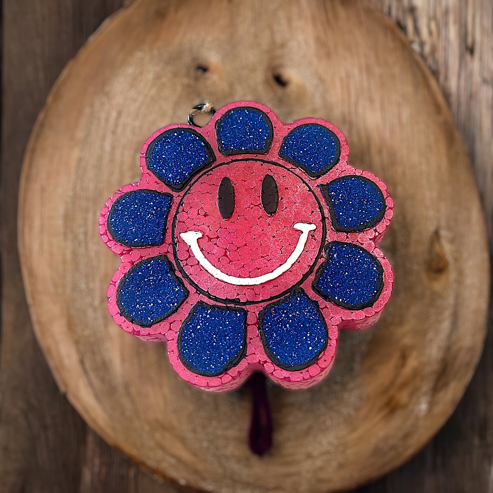 Flower-shaped sunflower with a smiley face design on a wooden surface