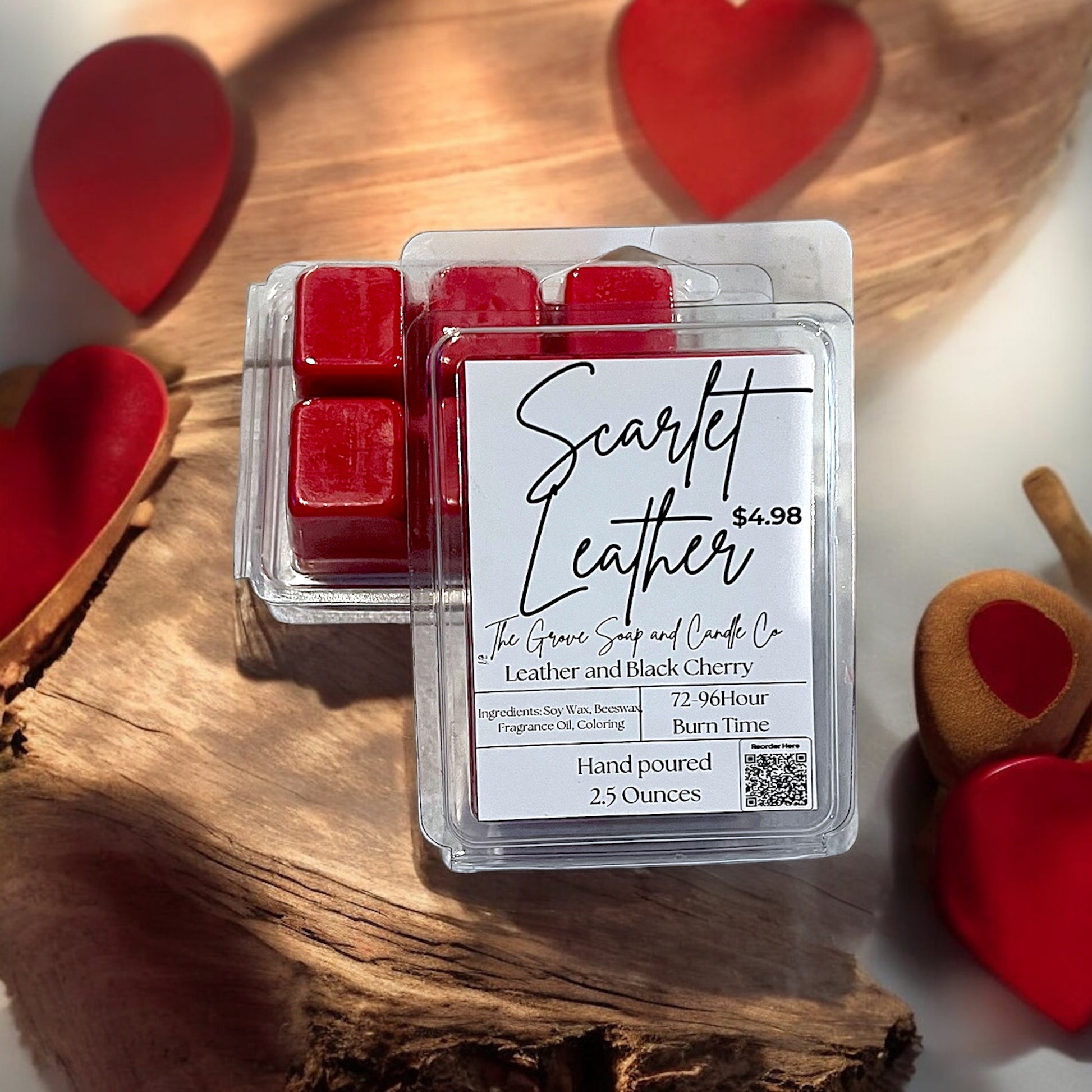 Scarlet Leather wax melts packaging on a wooden surface with heart-shaped objects. Label shows hand poured 2.5 ounce leather and black cherry scent.