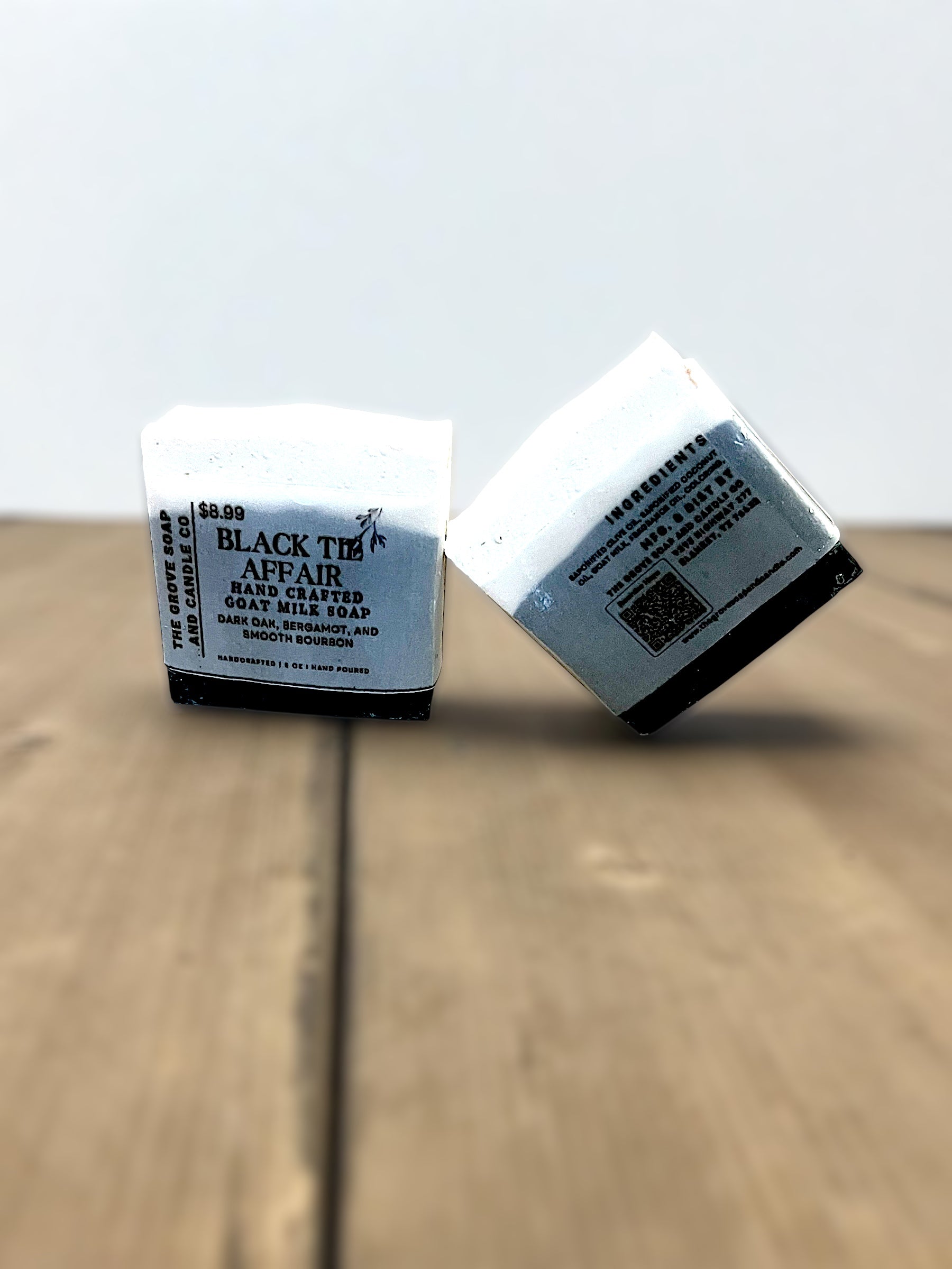 Two bars of soap with labels on a wooden surface