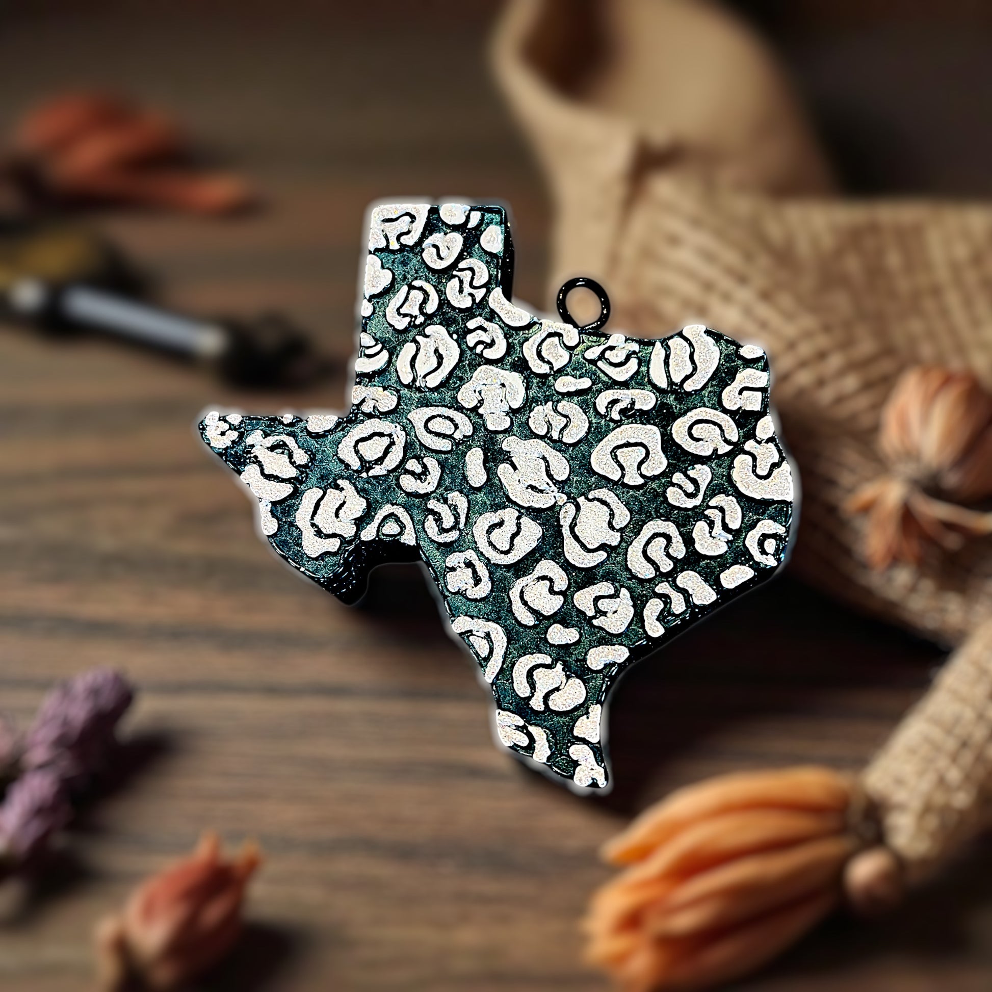 Dark blue highly scented car aroma beads with a leopard print pattern in white glitter on a wooden surface.