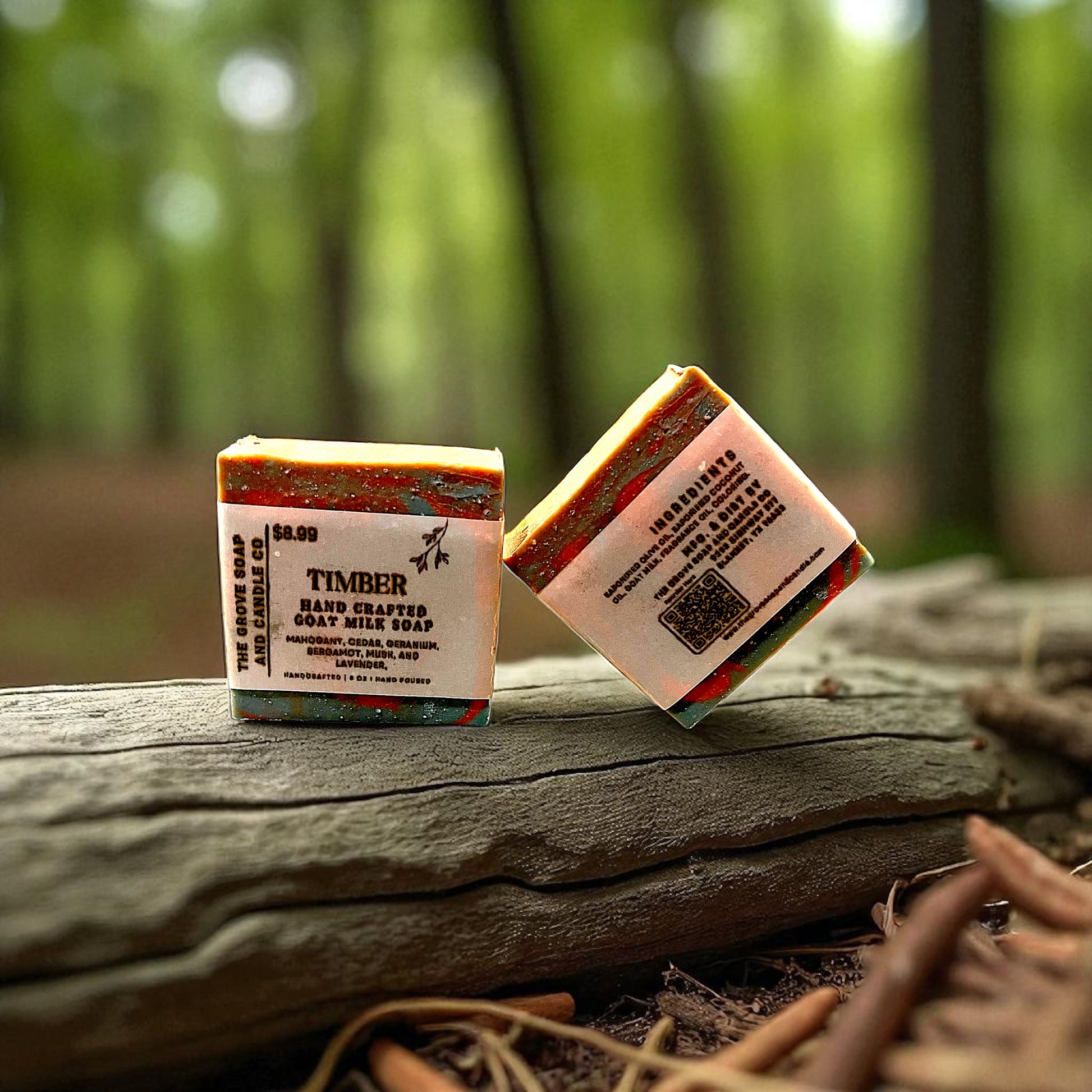 Two bars of soap with labels on a log in a forest setting