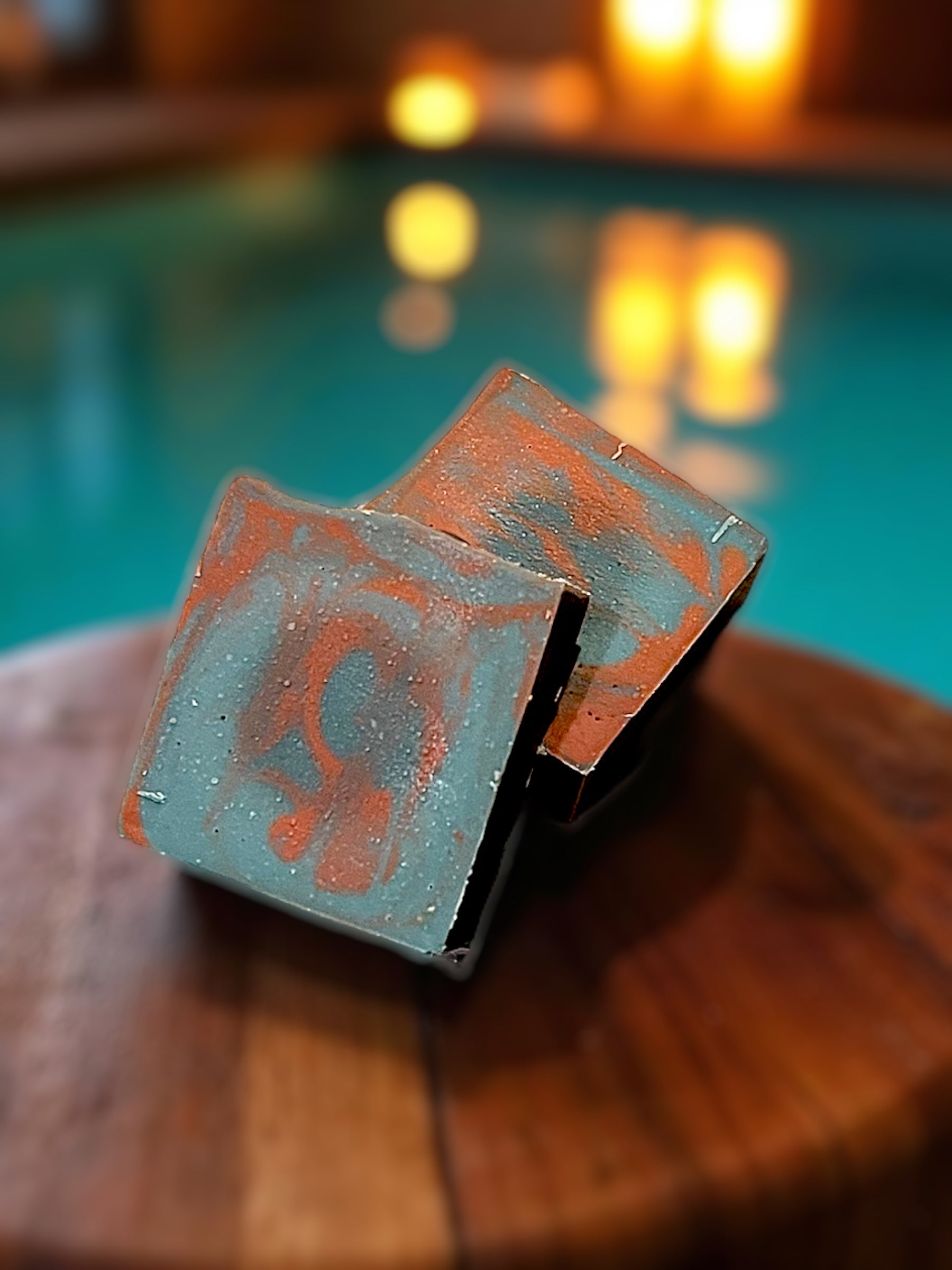 Decorative soap swirled in blue and brown on a wooden surface, pool in the background