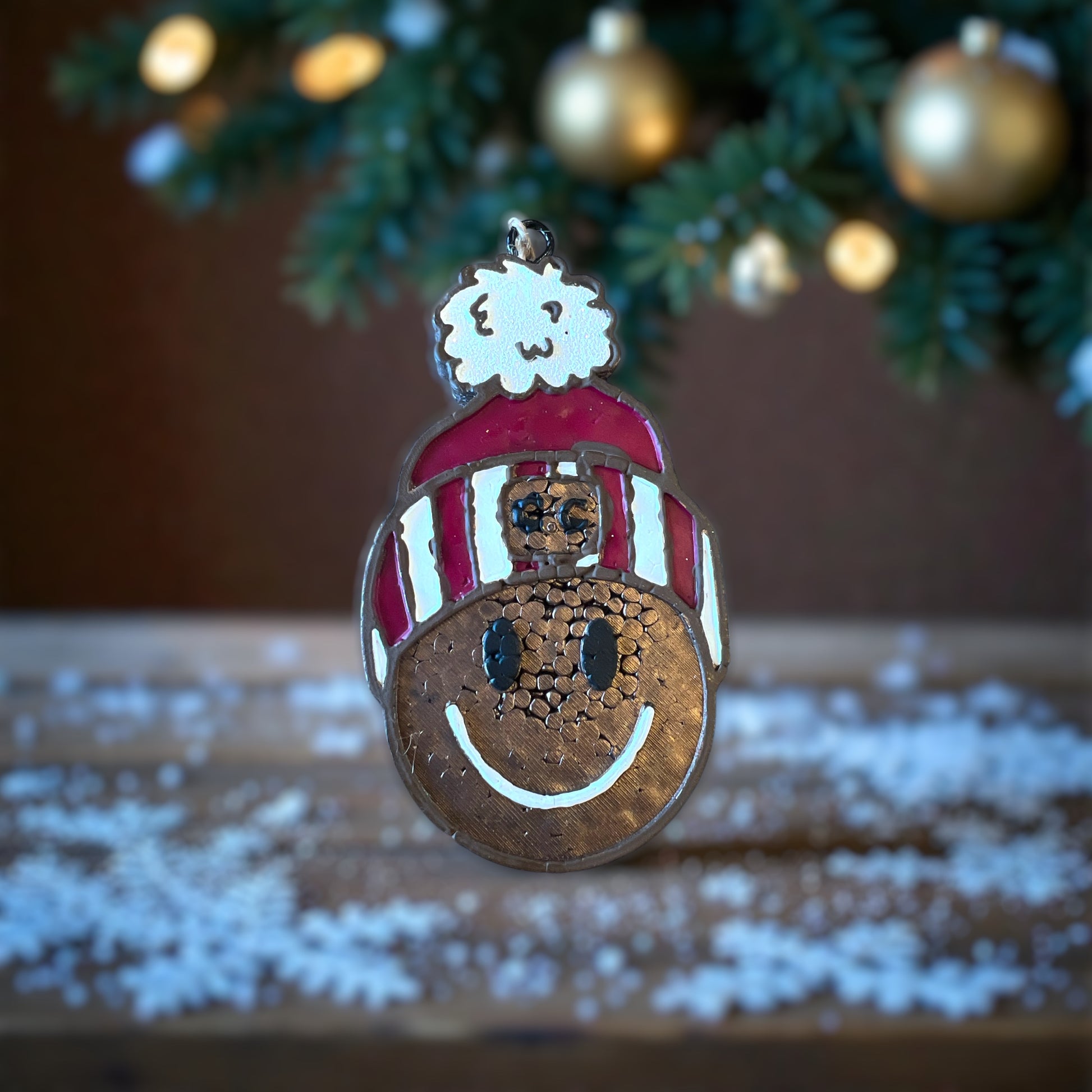 Beanie Waiting for this Season Car Freshie in brown with a maroon beanie and a white glitter pom pom on top. Sitting on a wooden table with greenery and snowflakes.