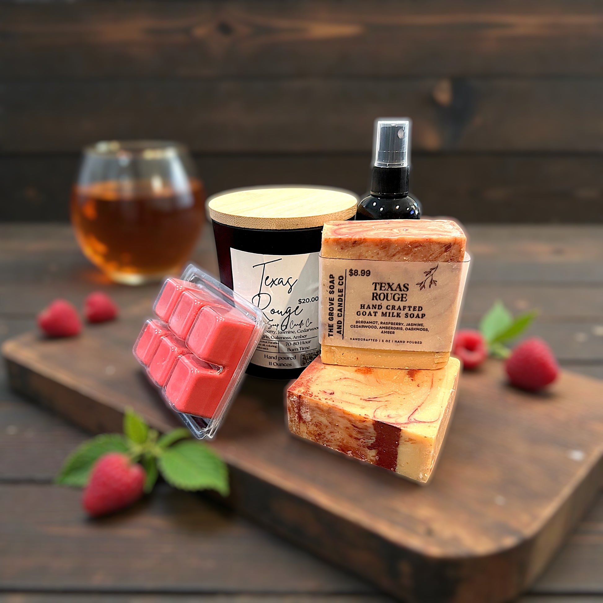 Assorted Texas-themed products including soap, candles, and a glass of amber liquid on a wooden surface.