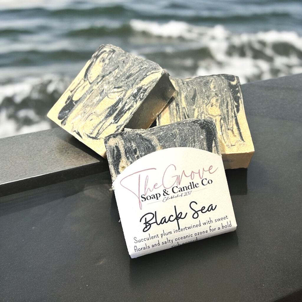 Handcrafted Black Sea goat milk soap bar on coastal-themed background. Depicting the ocean themed fragrance. 