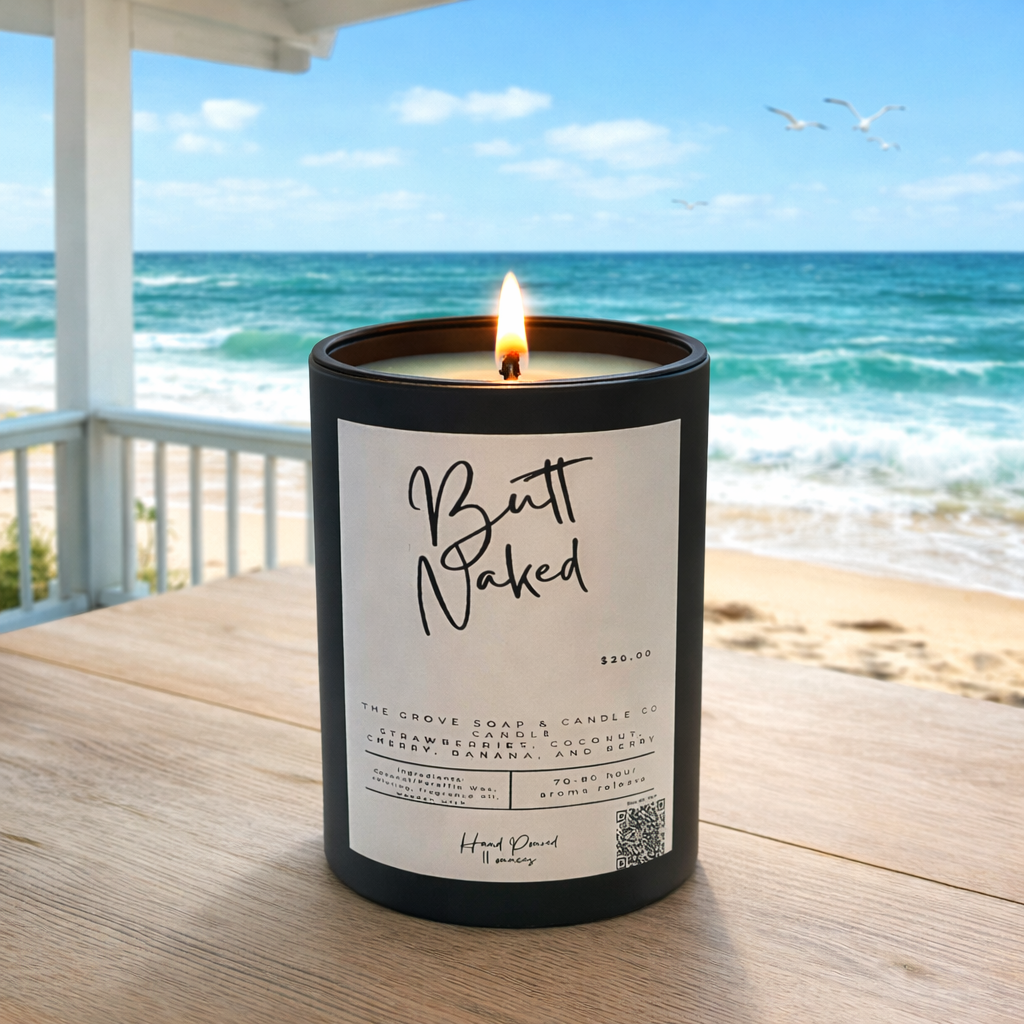Butt Naked tropical candle with strawberry, coconut, banana, and cherry fragrance with a lit wooden wick candle jar by The Grove Soap and Candle Co.