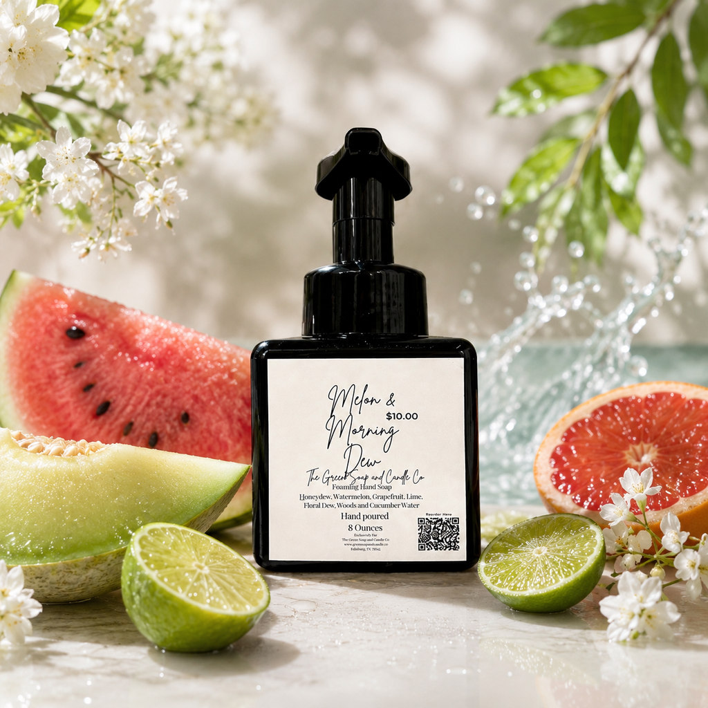 Black bottle of foaming hand soap with a label surrounded by fruits and flowers on a light background