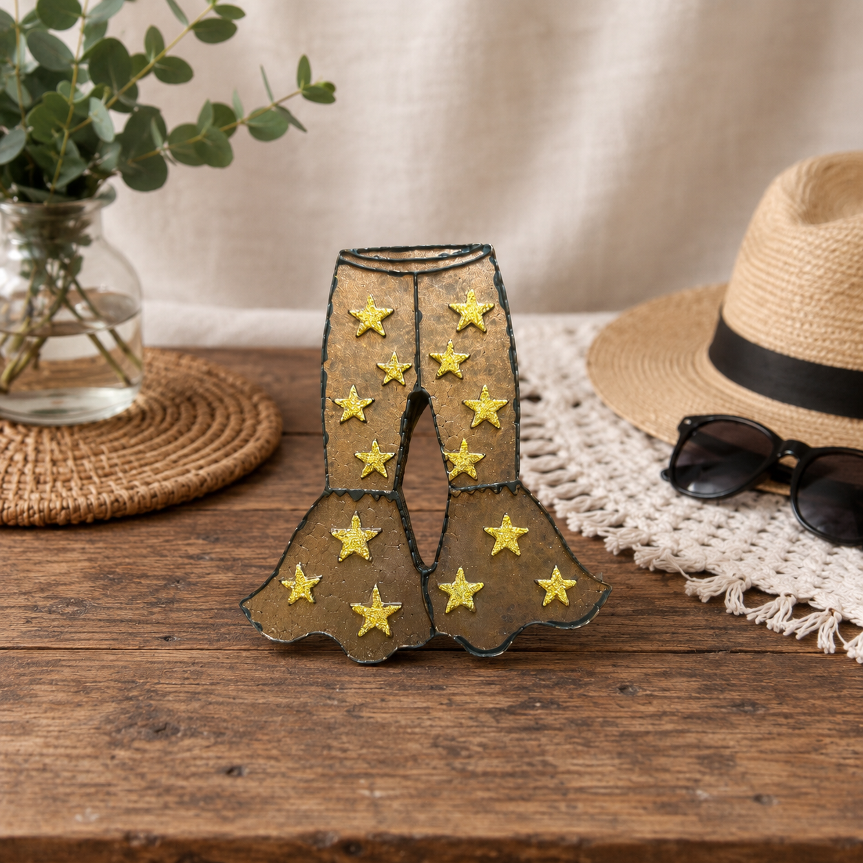 Fancy Pants Bellbottom Car Freshie with gold glitter stars sitting on a wooden table. 