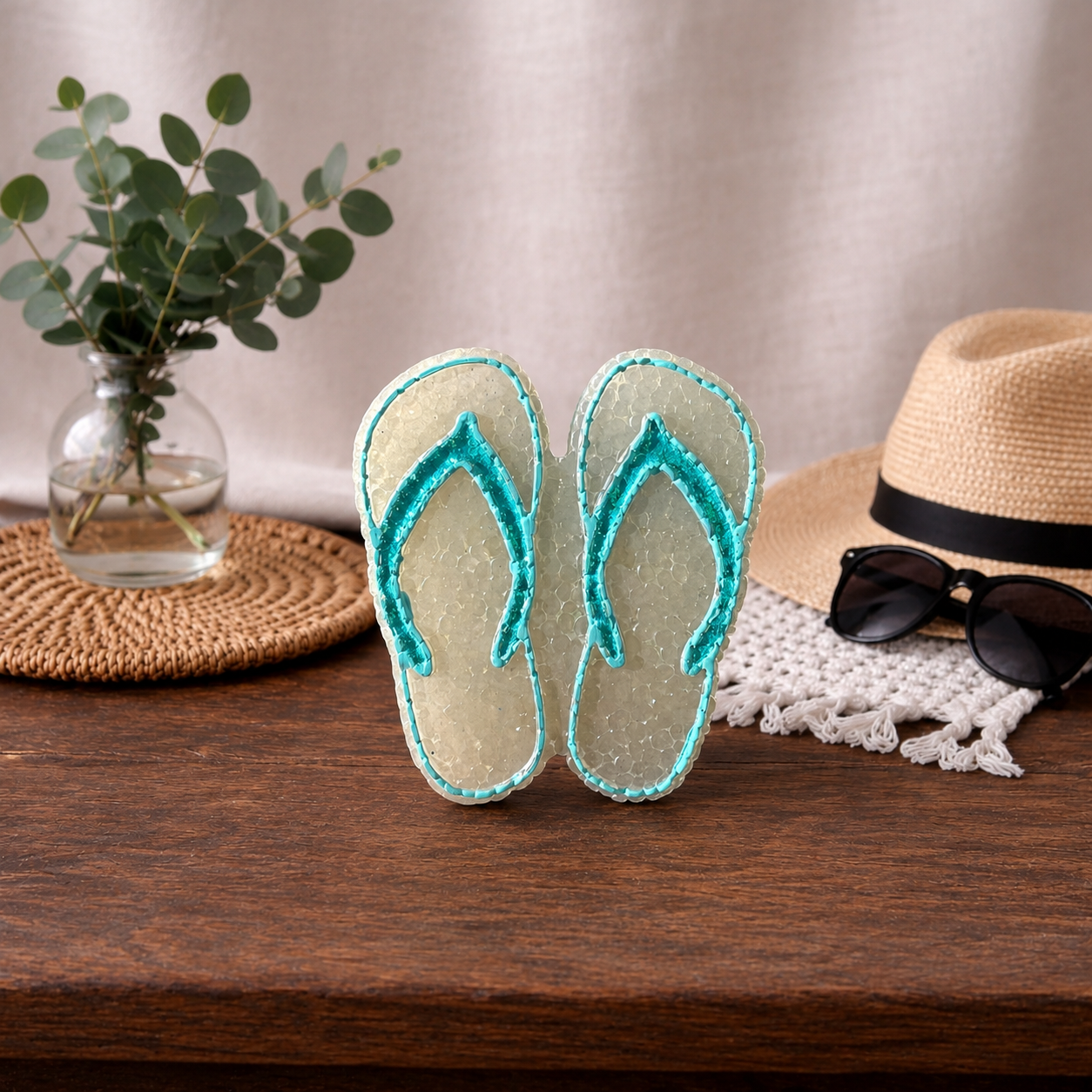 A pair of white and blue glitter flip flop car freshie on a wooden table