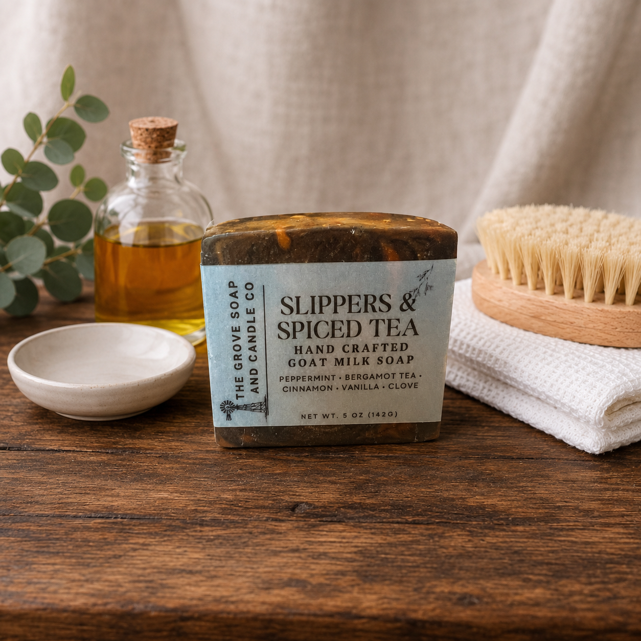 Slippers & Spiced Tea goat milk soap sitting on a wooden table. Label is shown to display scent profile and company logo