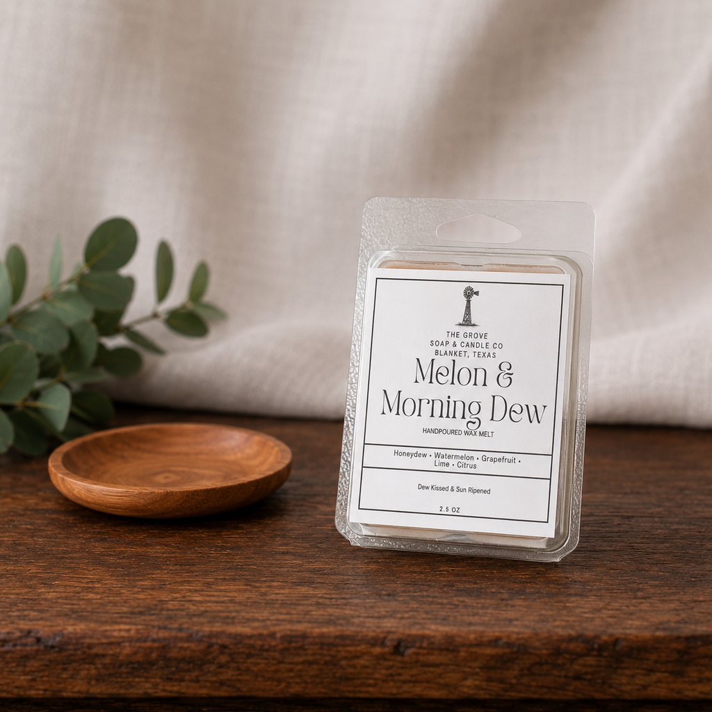 Melon & Morning Dew Wax Melt sitting on a wooden table with a linen background. Shows the packaging label