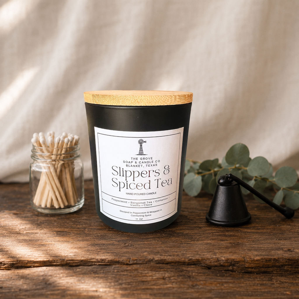 Slippers & Spiced Tea Candle sitting on a wooden table with a linen background. Shows the product label and scent profile