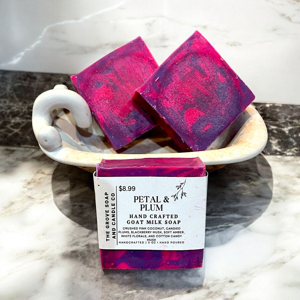 Up close photo of Petal & Plum hand crafted soap showing the label with the scent of crushed pink coconut, candied plums, white florals, blackberry musk, and cotton candy musk. 