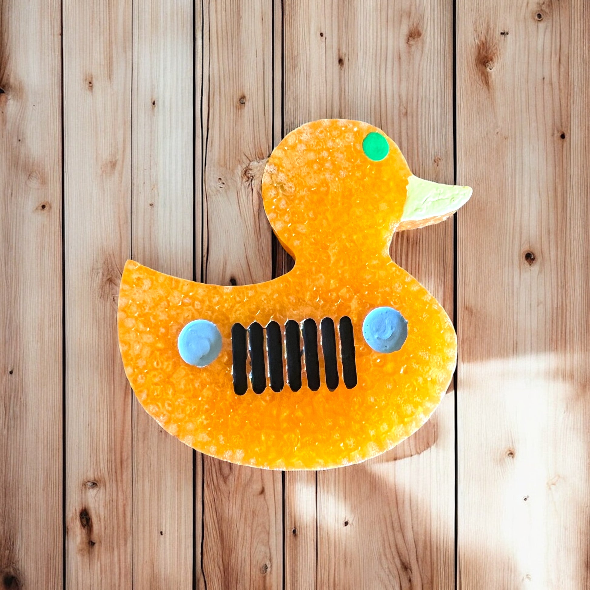 Orange rubber duck car freshie with grill  on a wooden background