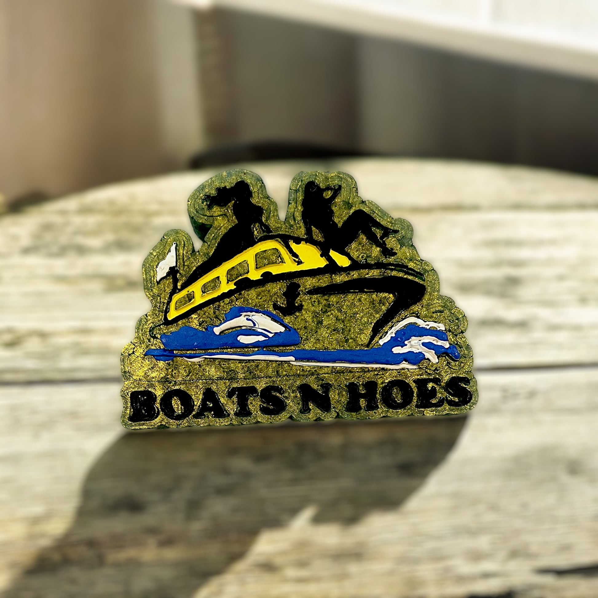 Decorative car freshie with 'BOATS N HOES' text on a textured surface