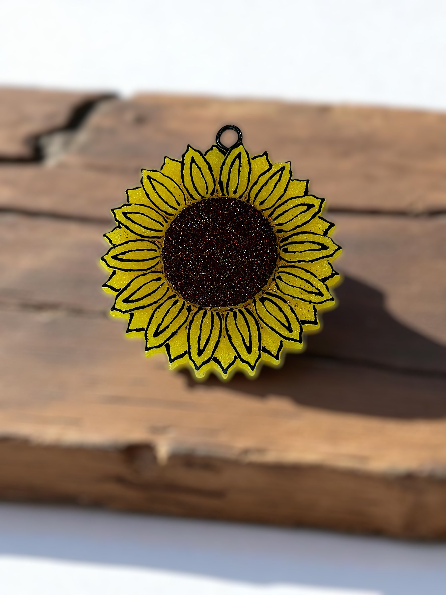 Yellow sunflower-shaped sunflower car freshie on a wooden surface
