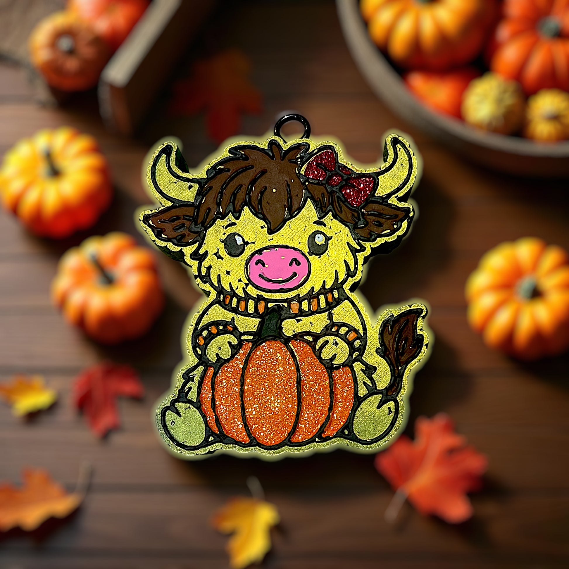 Illustration of a cartoon cow car freshie with a pumpkin on a wooden background with pumpkins and leaves.