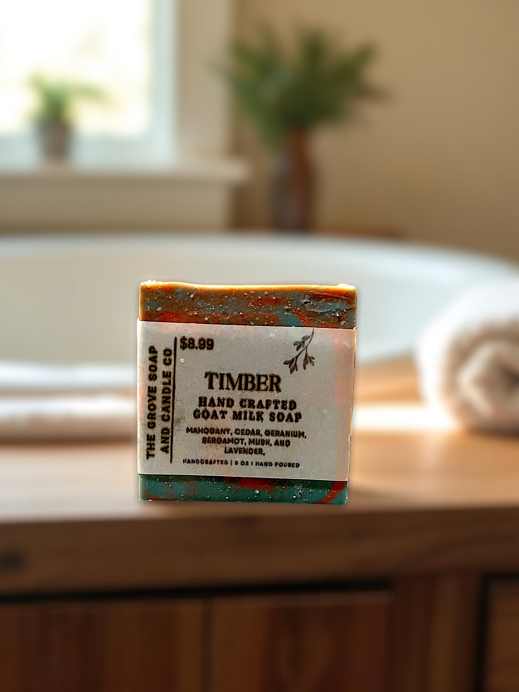 Bar of Timber handcrafted goat milk soap on a bathroom counter with blurred background