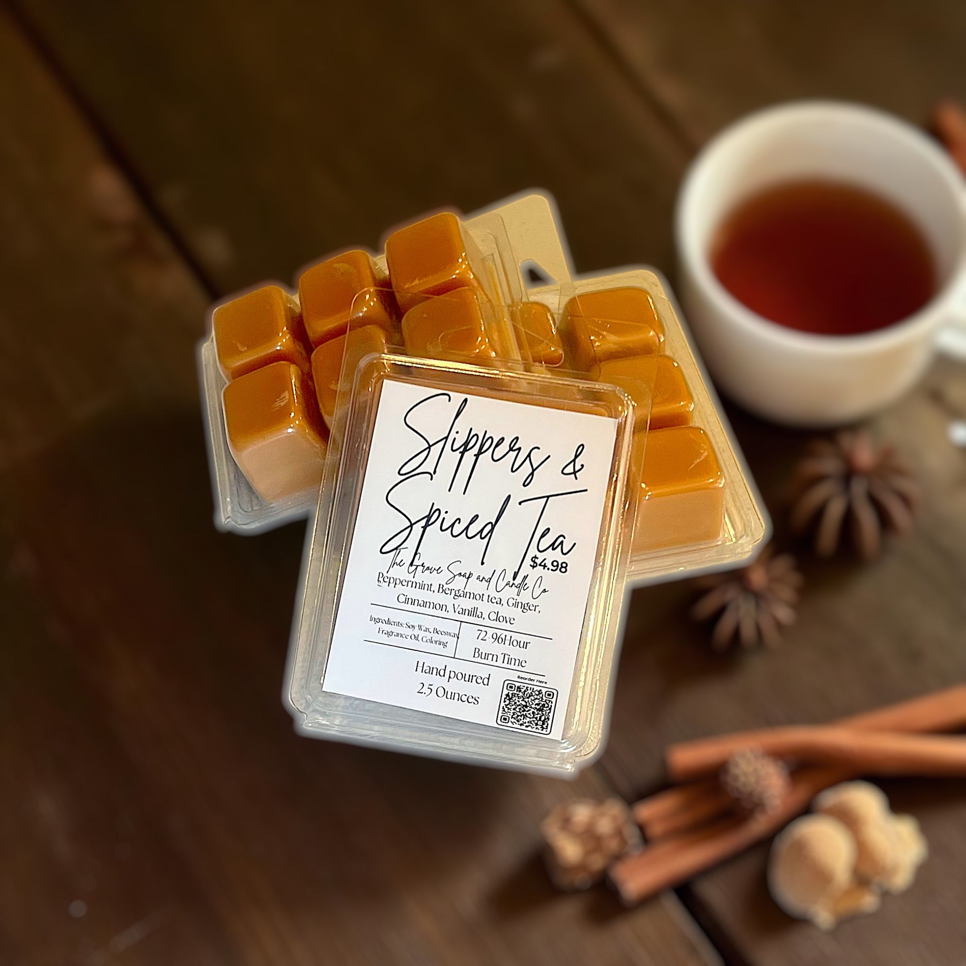 Packaged wax melts with a label for 'Slippers & Spiced Tea' on a wooden surface with a cup of tea and cinnamon sticks.