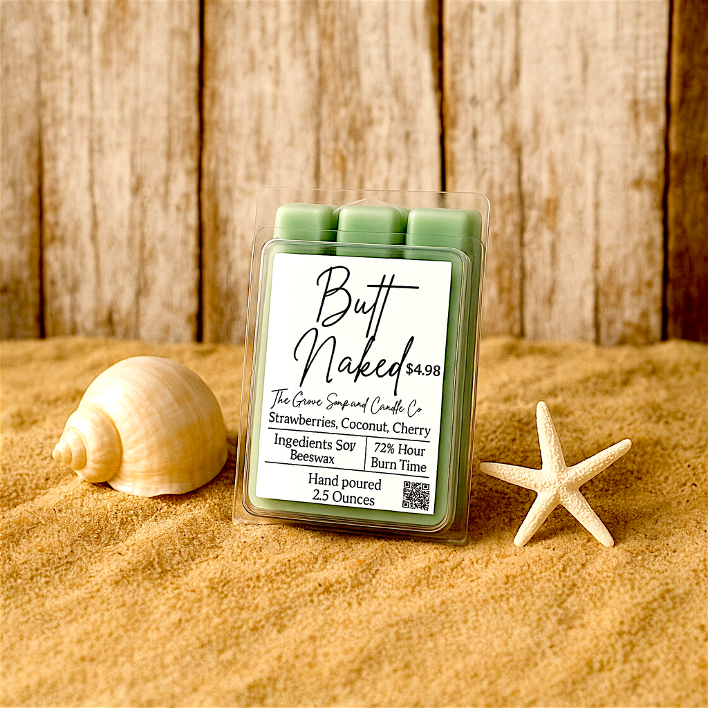 Candle wax melt package labeled 'Butt Naked' on sand with a shell and starfish.