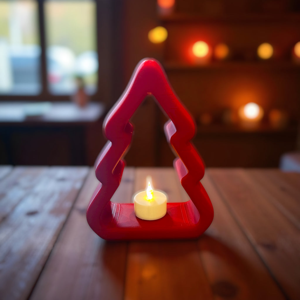 Red Christmas tree-shaped Tealight holder with a lit candle on a wooden table.