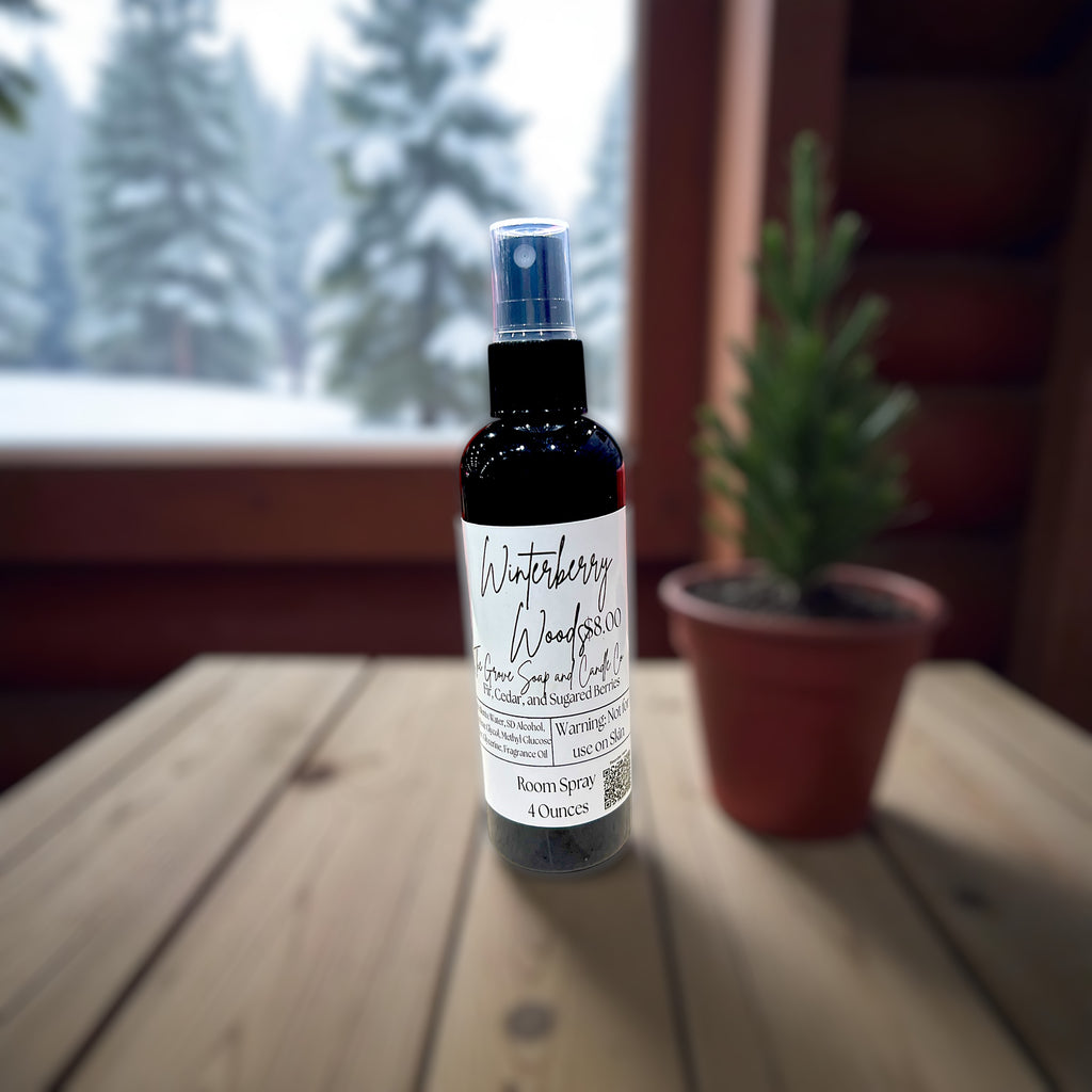 Bottle of Winterberry Woods Room Spray on a wooden surface with a blurred background