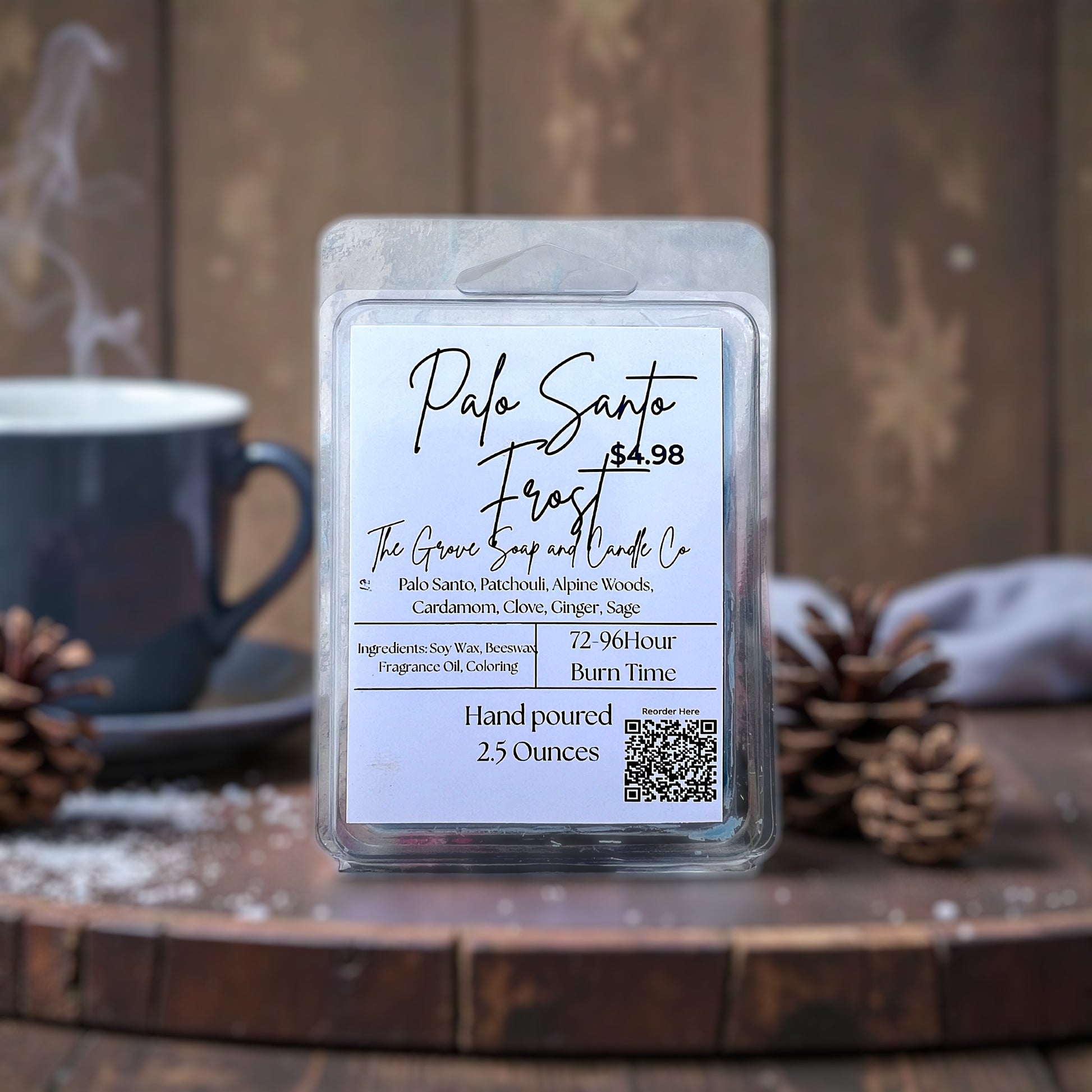 Palo Santo Frost wax melt packaging with label on a wooden surface with a cup and pine cones.