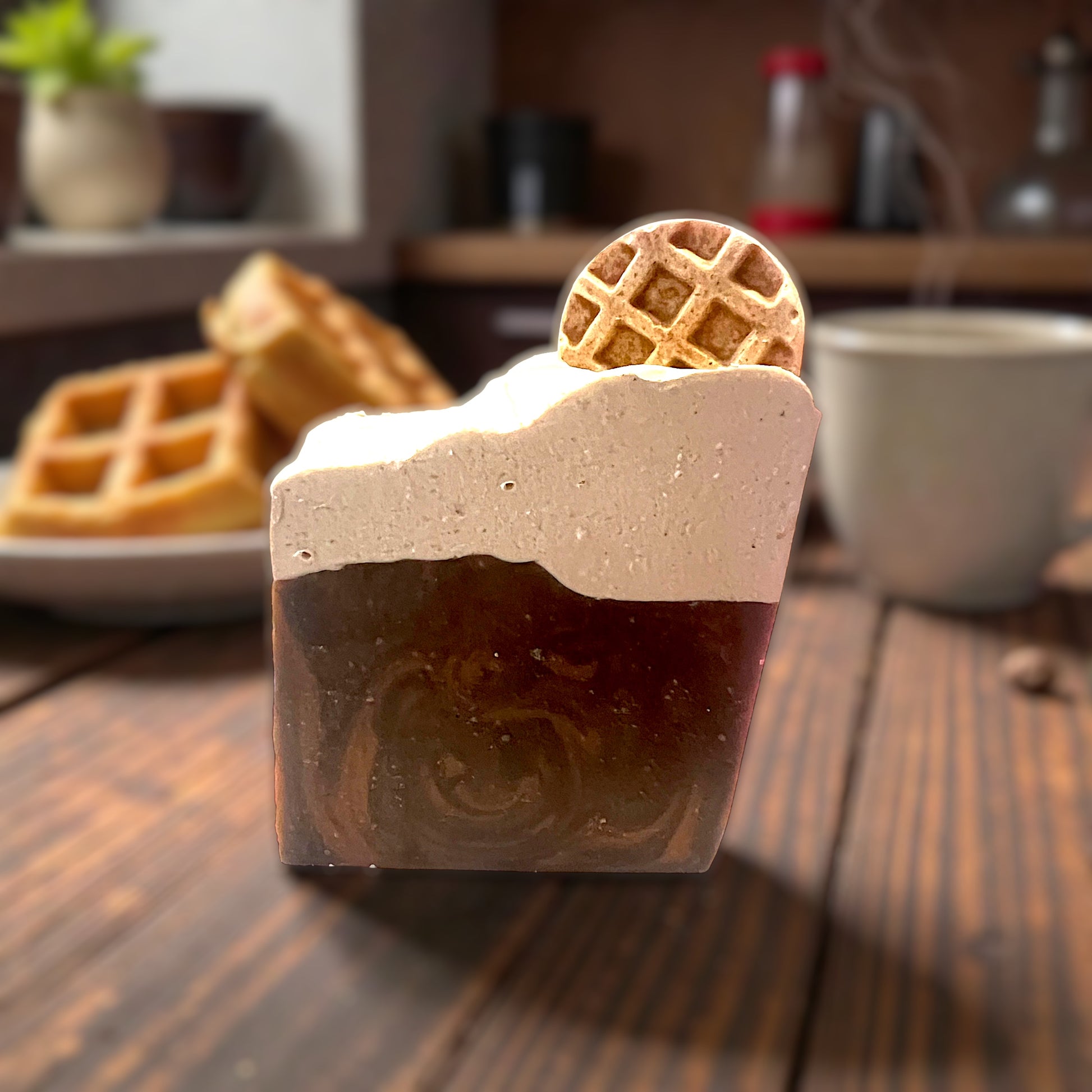 Chocolate swirled goat milk soap with whipped cream appearance on top and a waffle piece on a wooden table